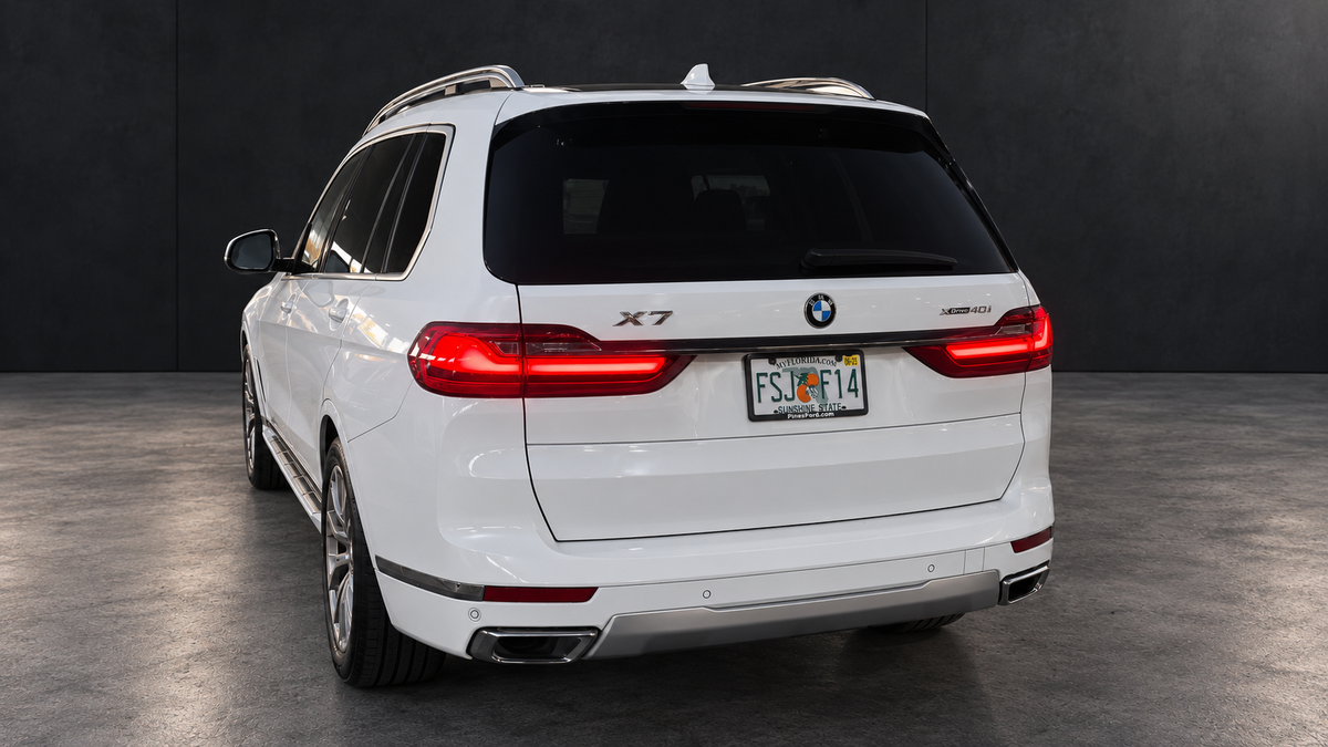 BMW X7 rear view with edited lighting and dark background.