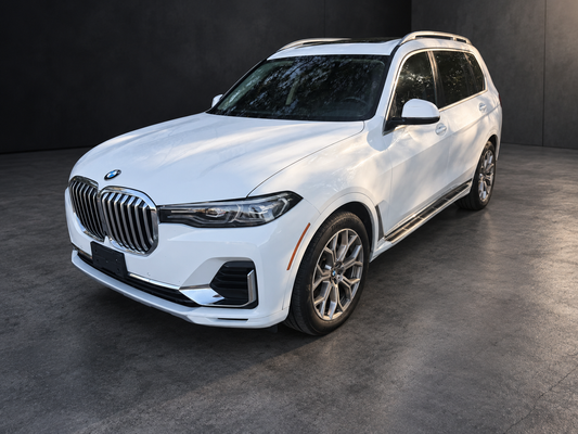 White BMW X7 shown at the same three-quarter angle with an edited dark architectural background.